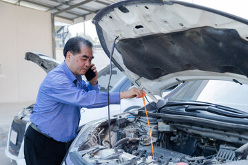 Garage small business or car insurance, middle-aged man calling for help while checking car engine, roadside situation reflecting breakdown problem, urgent communication for mechanical assistance