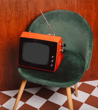 Retro CRT television on green vintage chair indoors