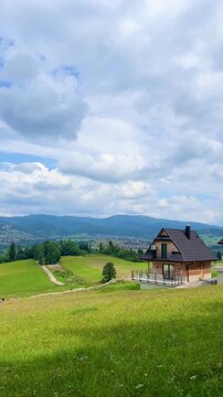 Panoramic view of traditional modern houses near Czorsztynskie lake with Tatra mountain background. Concept: rural lifestyle, eco living, authentic travel.
