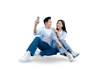A young couple sitting and smiling taking selfie. A man and woman sitting near each other looking at the phone, smiling and gesturing on PNG background