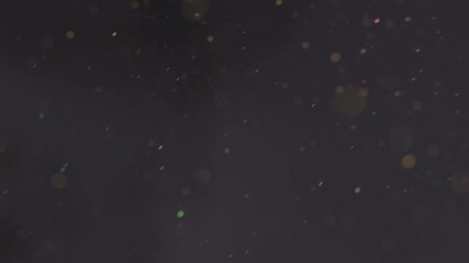 Floating dust particles in a dark environment. Abstract space texture. Bokeh effect on microscopic elements for background footage. - Powered by Adobe