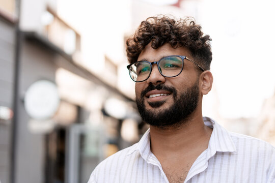 Young Indian Man Smiling and Wearing Glasses in Urban Setting