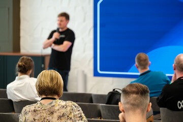 Speaker giving a presentation to seated audience during a workshop in a professional setting