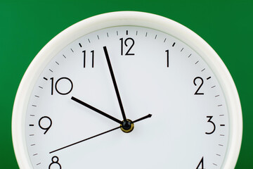 Clock telling time and working on time. Photo of clock in studio with green background.