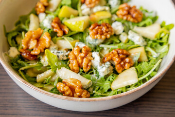healthy fall salad with arugula pear cheese and candied walnuts