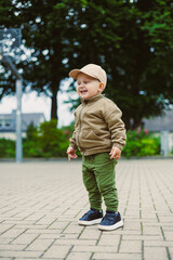 Fototapeta premium A joyful toddler in casual clothing enjoys playful moments in a vibrant park, showcasing innocence and energy while exploring, all with a big smile radiating joy and excitement for life