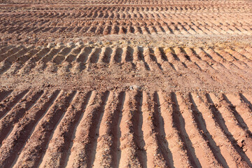 Background image showing tracks left by a tracked engineering vehicle on a dirt road surface