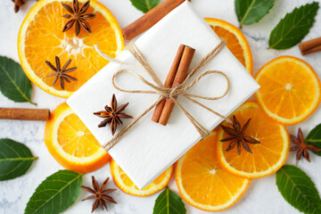 A gift box with orange slices and cinnamon sticks isolated on white background