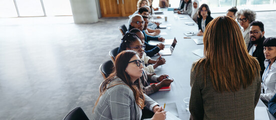 Businesswoman leading a meeting with diverse team in conference room