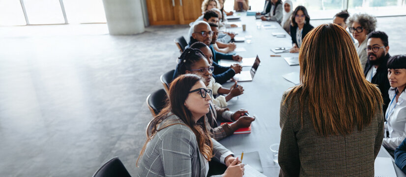 Businesswoman leading a meeting with diverse team in conference room
