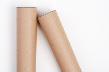 Two long cardboard tubes lying on white background