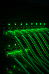 Close-up view of modern internet network switch with plugged ethernet cables. Blinking green lights on internet server