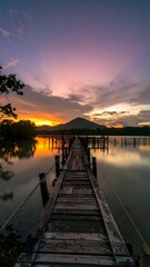 Obraz premium Wooden dock at sunset over calm water
