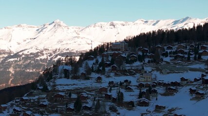 Drone aerial of Chandolin, Switzerland. Traditional alpine village with wooden chalets, snowy slopes and mountain peaks. Perfect winter tourism, travel and cinematic stock footage. - Powered by Adobe