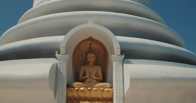 Japanese Peace Temple In Rumassala, Galle, Sri Lanka. Close up Famous landmark and cultural sacred place. The golden statue of Lord Buddha in Parinirvana, Japanese Peace Pagoda. View of the Japanese