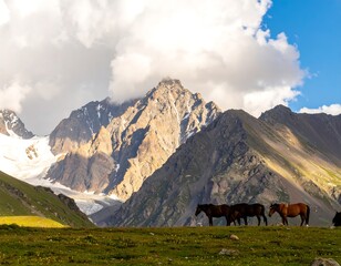 Majestic mountain range under a partly cloudy sky, three horses graze peacefully in the foreground