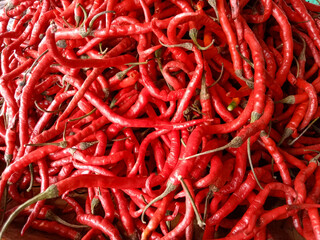 Curly red chili peppers. Red hot chili peppers. Curly red chili peppers on the market. Top view.