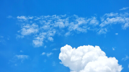 A vibrant blue sky with a large, Puff, cumulus cloud and scattered smaller clouds, creating a dynamic and refreshing natural scene. ldeal for backgrounds, concepts of freedom, or meteorological themes