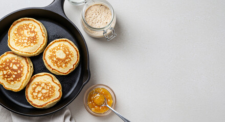 Homemade pancakes served in skillet with syrup and jar on table. Horizontal banner with copyspace, empty space for a text  