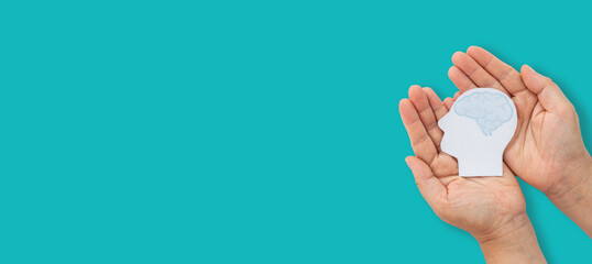 Mental health awareness, human hand care and support hold white paper head and glowing brain with physical and mental health, wellbeing, brain health, psychological support, healthcare and mindfulness
