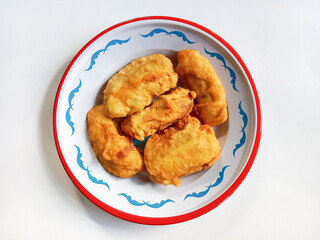 Fried Banana or Pisang Goreng. Banana Fritter. Fried banana served in a plate on white background. Indonesian food.