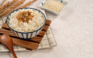 A bowl of white rice topped with sprinkle rice seasonings.