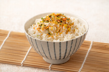 A bowl of white rice topped with sprinkle rice seasonings.