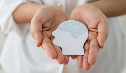 Mental health awareness, human hand care and support hold white paper head and glowing brain with physical and mental health, wellbeing, brain health, psychological support, healthcare and mindfulness