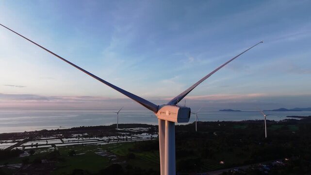 Aerial view of windmills towering over the landscape with a beautiful sunset creating a warm glow across the sky, Guimaras, Western Visayas, Philippines.