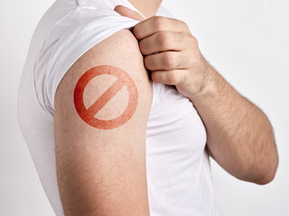 Man showing no symbol on his arm against vaccination