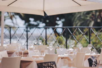 Elegant dining setup overlooking a picturesque view in a coastal restaurant during a sunny afternoon