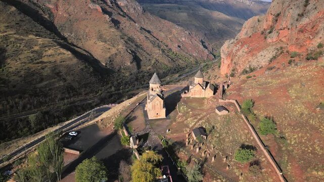 Aerial revealing view Noravank monastery complex, 13th-century Armenian monastery. Holy Mother of God church.Noravank at Amaghu. Red cliffs gorge by Arani village. Tourist destination in Armenia