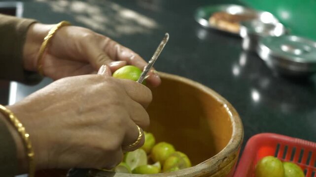 Indian housewife cutting lemons to make traditional lemon pickle, Closeup