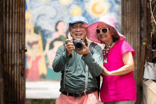 A happy senior couple strolling along a city's old neighborhood, enjoying travel
