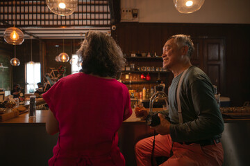Senior couple enjoying coffee in a cozy cafe,