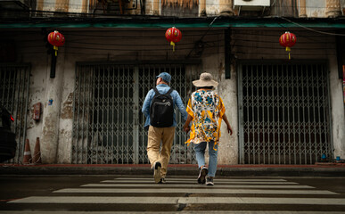 Obraz premium Happy senior couple walking on a city street, holding hands and sightseeing together,