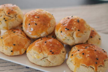 turkish savory pastry pogaca with dill and black sesame or cumin, homemade quick snack served on darck table and table cloth