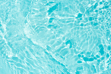 Obraz premium Blue water with ripples on the surface. Defocus blurred transparent blue colored clear calm water surface texture with splashes and bubbles. Water waves with shining pattern texture background.
