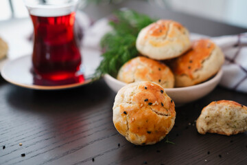 homemade turkish savory pastry pogaca with dill and black sesame or cumin, served with tea for breakfast or noon break