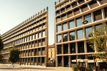 Fototapeta premium Modern Office Building with Symmetrical Glass Facade and Urban Architecture