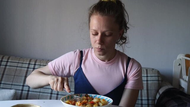 A young woman sits at a table savoring a delicious dish. She is focused on her meal, creating a warm and inviting atmosphere. Sunlight gently illuminates the space.
