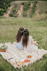Girls Enjoying a Picnic in a Scenic Field