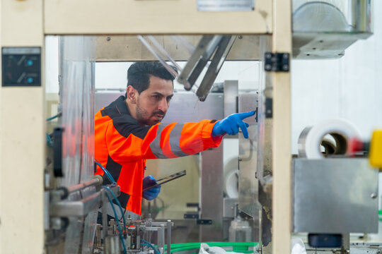 Male technician mechanical engineer maintenance and repairing automated conveyor belt system machine in canned food production line plant. Processed food factory industry business entrepreneur.