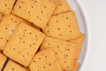 Whole grain crackers with flax and sesame seeds isolated on white background. Dry salted cracker cookies. Snack. Gluten free crackers