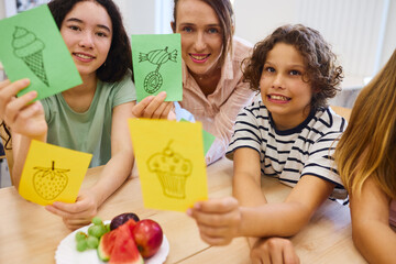Children learning about food choices together in classroom environment with teacher assistance