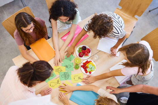 Students gathered around a table engaging in an educational activity session