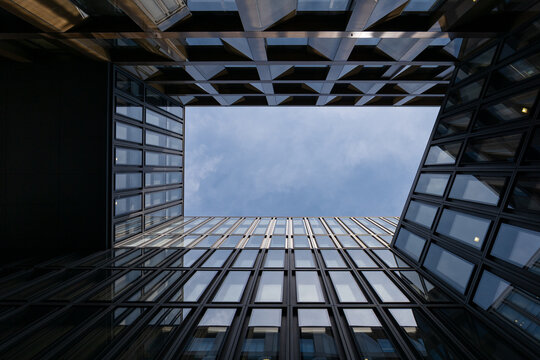 Zurich, Switzerland - 25th June 2025: Europaallee office and shoping area. Looking up at modern office buildings with glass facades. Urban architecture and commercial real estate against a blue sky.