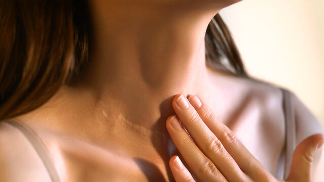 Close-up of an unrecognizable woman touching her neck. Endocrine health prevention. Diseases of the thyroid gland. Cancer screening. Endocrinology. Concept of medicine and health care. Self care