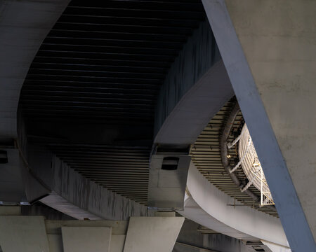 Close-up architectural view of Western High-Speed Diameter bridge in Saint Petersburg, showing concrete pillars, curved underside, and structural engineering details. - Powered by Adobe