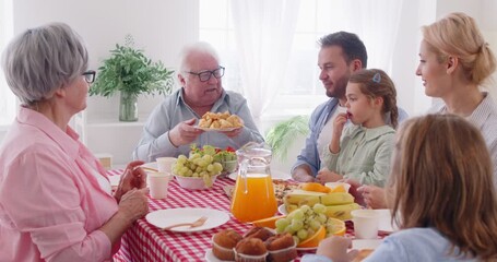 Happy family gathered, close loving people eating together, three generations in connection enjoying, taking sharing at table to enjoy common dinner, lunch, grandparents, parents, children together